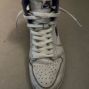 Jordan 1s high court purple - Säljer ett par klassiska Nike jordans sneakers i vitt med lila detaljer. Skorna har snörning och är i bra skick med lite slitage. Perfekta för både vardag och träning. De har en hög modell med bekväm passform. Pris kan diskuteras.