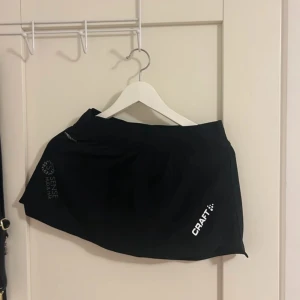 Svarta träningsshorts från Craft med inbyggda shorts  - Säljer ett par svarta träningsshorts från Craft i mycket bra skick . Perfekta för löpning eller gymmet. De har en bekväm passform och är gjorda i ett lätt och andningsbart material. Loggan syns tydligt på sidan. Passar perfekt för sommarträning!