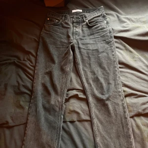 Svarta jeans från Whyred - Säljer ett par snygga svarta jeans från Whyred i bra skick. Relaxed fit och de har knappar i gylfen. 