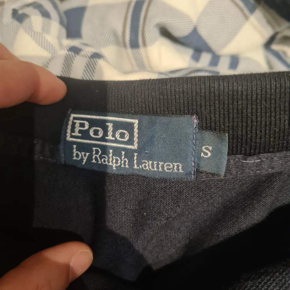 Säljer en snygg mörkblå pikétröja från Ralph Lauren i storlek S. Tröjan har långa ärmar och den klassiska loggan broderad i gult på bröstet. Perfekt för både vardag och fest! 🐎. Tröjor & Koftor.