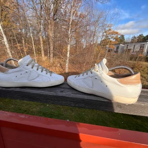 Vita sneakers med beige detaljer - Säljer ett par vita sneakers i bra skick med beige detaljer på hälen. Skorna har snörning och är perfekta för vardagsbruk. De har en klassisk design och är bekväma att bära. Perfekta för vår och sommar!