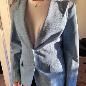 Ljusblå kavaj  - En denim färgad kavaj med tunn  manchester. Lätt figursydd och nästan oanvänd. Fodrad. Storlek 36 men passar även lite större. Skriv för mått