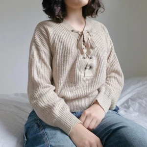Beige stickad tröja - Söt oversized tröja med knytdetalj/ snörning framtill 🌸  Lite nopprig, annars inget att anmärka på. Svarar gärna på frågor, det är bara att skicka ett meddelande :)