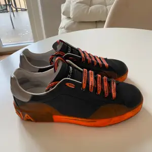 Säljer ett par Dolce & Gabbana sneakers i svart och orange. Använda men i gott skick, och fortfarande riktigt snygga och bekväma!  -Storlek 43 herr