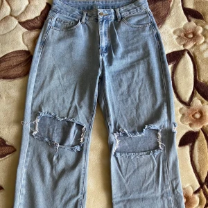 Ljusblå jeans med revor  - Snygga jeans från shein! Bra kvalitet trots märket. Ingen stretch. Fanns en ”spricka” längs höger knä - ihopsytt (bild 3). Annars felfritt. Fungerande dragkedja, hela byxfickor. Raka ben, hög midja.  Stl. Petite M (38) Nypris: 159 kr 