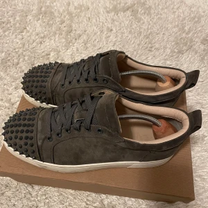 Svarta sneakers med nitar - säljer mina 1 år gamla louboutins. De har en snygg och unik design med snörning och en vit sula. väldigt bra skick och använda sparsamt. nypris 8800 säljer mina för 2800. priset är ej hugget i sten så hör av dig!