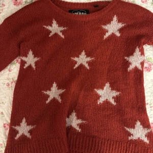 Stickad röd tröja med stjärnor - Gosig, stickad, röd tröja med vita stjärnor.  