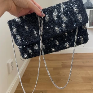 Beck Söndergaard väska - Så sjukt snygg och elegant clutch från Beck Söndergaard! Litet hål på undersidan mellan inneväskan och utsidan av väskan så därav är inte hålet rakt igenom hela väskan (se bild 5) Annars superfin💕💕💕🥰