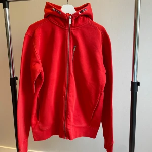 Sail Racing tröja - Röd trendig Sail Racing zip hoodie till salu som tyvärr aldrig kom till användning. Nypris 900kr 