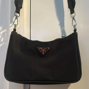 Prada handväska - En svart oäkta Prada axelremsväska/ handväska! Den är i nyskick och mycket bra kvalite! Pris kan diskuteras!