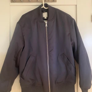 Blå bomberjacka oversize - Jättefin blå oversized bomberjacka från H&M. Är från herr-avdelningen i storlek XS men sitter som en oversize jacka för tjejer. Använd fåtal gånger och i mycket bra skick