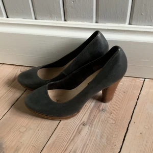 Pumps  - Svarta pumps i äkta skinn med brun träklack. Använda några tillfällen men bra skick.