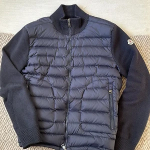 Moncler cardigan - Säljer denna Moncler Cardigan som är i storlek M. Inga större defekter, bra skick. Kan ej garantera äkthet då jag inte har kvitto men har tags osv. QR koden och NFC scannern funkar! Han jag köpte av sa att den va äkta.