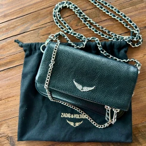 Zadig & Voltaire - Rock Nano handväska - Svart skinnväska med silver detaljer från Zadig Voltaire i nyskick, använd fåtal gånger.  Inköpspris: 2350kr Kvitto finns, inköpt på zalando. Dustbag kommer ingår i köpet. 