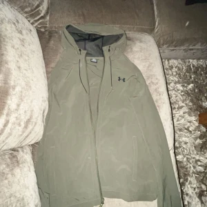 Under armour jacka - Tjena jag säljer min under armour jacka eftersom jag har köpt en annan. Det är en windbreaker som tål vatten till viss del, inga skador eller fläckar. Den är som ny o har använts i 2 månader. Om du har nån fråga eller liknande är det bara att skriva😃