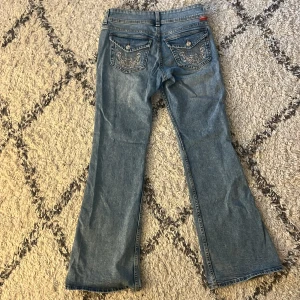 Lågmidjade jeans - Säljer ett par blå bootcutjeans från hm  med mönster på fickorna där bak i storlek 38🤗 lite korta i benen för mig som är 175cm men annars bra och i fint skick! Skicka dm för frågor eller fler bilder💖