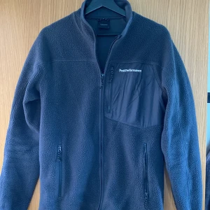 Peak Performance Ullcardigan S - Jag säljer denna Ullcardigan från Peak Performance i storlek S i grå färg då jag inte längre kan ha den. Den är i väldigt fint material och pris kan diskuteras vid snabb affär.