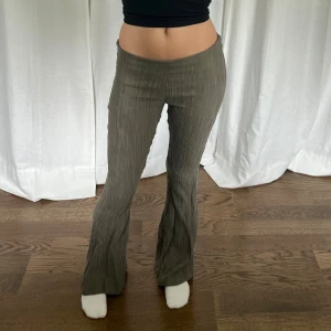 Bootcut byxor - Mörkgröna / khaki färgade lågmidjade bootcut byxor från Bella Hadid x About You. Midjemått: 80-86 cm. Innerbenslängd: 87 cm. Jag är 176 cm. Dragkedja på sidan 💘
