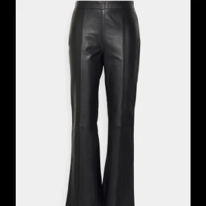 Svarta skinnbyxor med bootcut - Säljer ett par snygga svarta skinnbyxor med bootcut. De är högmidjade och har en stilren design som passar perfekt för både vardag och fest. Byxorna är i nyskick och ger en cool och trendig look.