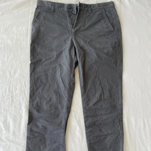 Grå slim fit byxor från H&M - Säljer ett par grå slim fit byxor från H&M i storlek 30/32. Byxorna är i bra skick och har en klassisk design med dragkedja och knappar. Perfekta för både vardag och fest! Frågor? Skriv!