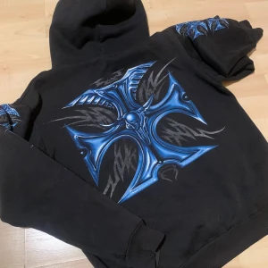 Cool svart hoodie - Superbra skick! Cool hoodie med blått kors på! 