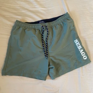 Gröna badshorts från Sebago - Säljer badshorts från Sebago i storlek L. De är sparsamt använda och i bra skick, men sitter mer som M än L. Tveka inte att höra av dig om du har frågor eller vill ha fler bilder! 