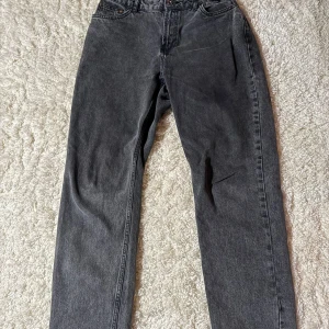 Grå jeans från Grunt - Säljer ett par grå jeans från Grunt i bra skick. De har en klassisk straight passform och är tillverkade i bomull. Perfekta för både vardag och fest. De har en knappgylf och fem fickor. Passar till alla säsonger!