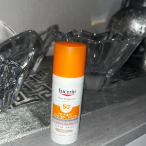 Eucerin Sun Gel-Cream SPF 50+ - Eucerin Sun Gel-Cream med SPF 50+ är en tonad solskyddsprodukt som hjälper till att kontrollera pigmentering. Den är anpassad för alla hudtoner och har en lätt gel-kräm konsistens. Perfekt för att skydda huden mot solens skadliga strålar samtidigt som den ger en jämnare hudton. Lådan kommer med