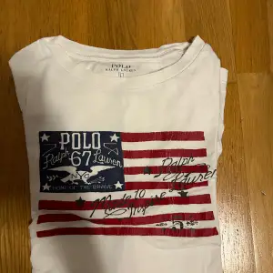 Fin vit polo tshirt med flagga på framsidan. Storlek 14-16 L barnstorlek = S herrstorlek