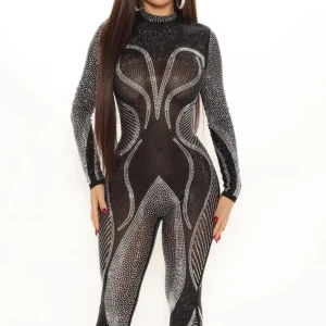 Svart glittrig jumpsuit - Snygg svart jumpsuit med glittriga detaljer som verkligen fångar ljuset. Den har en tight passform och långa ärmar, perfekt för en festkväll. Materialet är stretchigt och bekvämt, vilket gör den lätt att röra sig i. Den höga halsen ger en elegant touch.