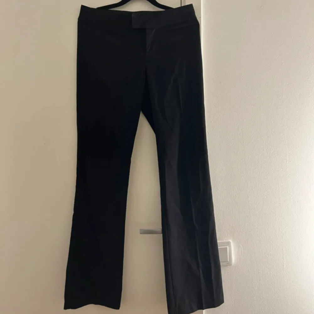 Snygga svarta kostymbyxor i bra skick. De har en klassisk bootcut-stil som ger en elegant look. Perfekta för både kontoret och festliga tillfällen. Passar bra till en skjorta eller blus för en stilren outfit.. Jeans & Byxor.