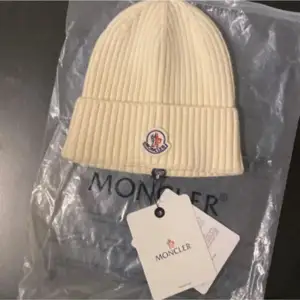 Säljer en snygg mössa från Moncler. Perfekt för att hålla sig varm och stilren under kyliga dagar. Mössan är i nytt skick och kommer med originalförpackning. Passar perfekt till både vardag och lite finare tillfällen. Ett måste för vintern! ❄️