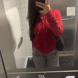 Röd hoodie med dragkedja - Säljer en snygg röd hoodie med dragkedja och huva. Perfekt för höst och vinter, den är både bekväm och stilren. Passar bra till vardags och är i bra skick. Storleken är normal och den har praktiska fickor framtill. 