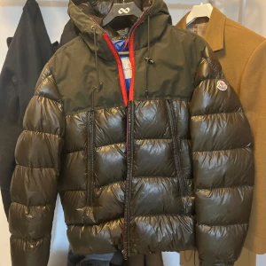 Moncler Eymeric Dunjacka Olivgrön  - Säljer en snygg Moncler Eymeric Dunjacka Olivgrön i använt skick.  Jackan har använts ganska mycket och är inte i bästa skicka. Detta är en collection jacka säljs inte mer på affärer slutsålt och äldre modell från 2017. Storleken M på jacka. 