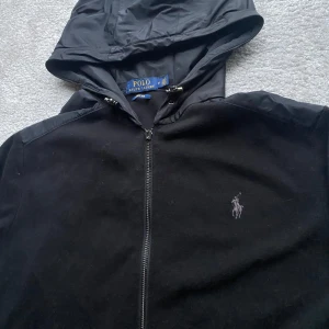 Cardigan Polo Ralph Lauren - En riktigt fet cardigan från märket Polo Ralph Lauren🐺 | Skick 7/10- Drag kedjan framtill har lossnat men funkar ändå som den ska och syns inte vid användning✅| perfekt nu i sen höst att ha med en tjock tröja under❗️| Hör av er vid fler frågor eller bilder🦦| StockholmWRDB 