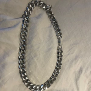 Silverfärgat halsband - Snyggt och stilrent silverfärgat halsband med tjocka länkar. Perfekt för att ge en edgy touch till vilken outfit som helst. Passar både till vardags och festliga tillfällen. Ett måste för den som gillar att sticka ut!