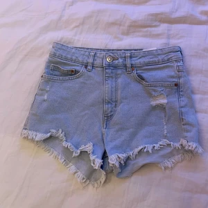 Snygga jeansshorts från H&M Divided - Ett par blå jeansshorts från divided by H&M. Knappt använda och utan defekter (hålen och det slitna är meningen). Riktigt snygga men passar mig tyvärr inte längre.🩵