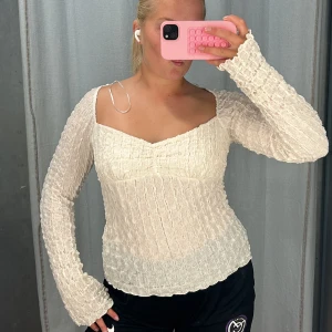 Vit ribbad långärmad topp - Säljer en superfin vit ribbad topp som aldrig är använd. perfekt för både vardag och fest. Toppen är i ett stretchigt material. Passar perfekt till jeans eller kjol