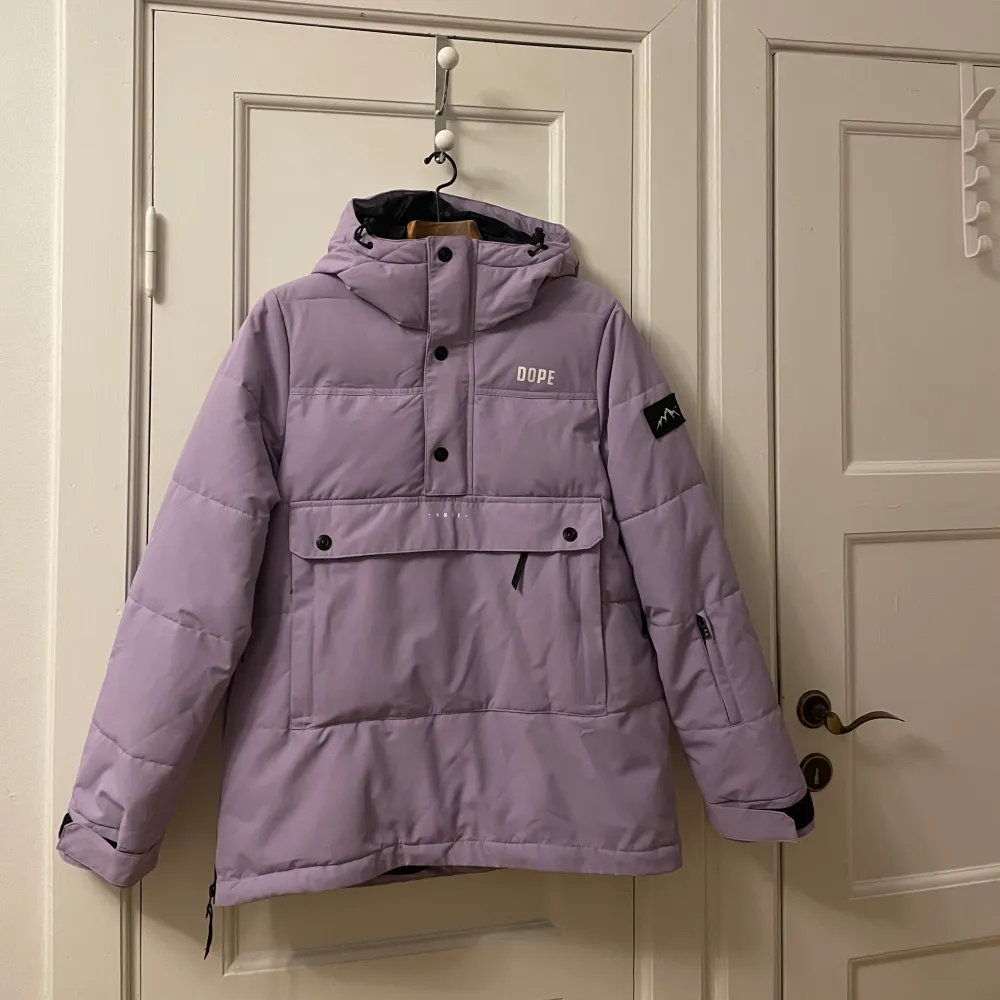 Säljer en snygg lila pufferjacka från Dope i storlek S. Jackan har en stor ficka framtill med knappar och dragkedja, samt en justerbar huva. Den är använd ett få tal gånger och är som ny, inga defekter. Hör av er om ni har några frågor 💕🎿. Takit.