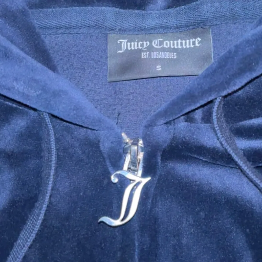 Säljer en supermjuk och snygg mörkblå hoodie från Juicy Couture. Den har en dragkedja med ett coolt J-hänge och broderad logga på bröstet. Perfekt för en chill dag eller en avslappnad utekväll. 🧥✨ I färgen Blue depths, perfekt skick. Nypris: 1300kr, säljer för: 750kr. Hoodies.