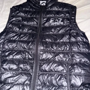 Svart dunväst från Emporio Armani -  Svart väst från Armani äkta den är som nytt skick knappt använd och allting kvar från när man köpte den kom med pris förslag 
