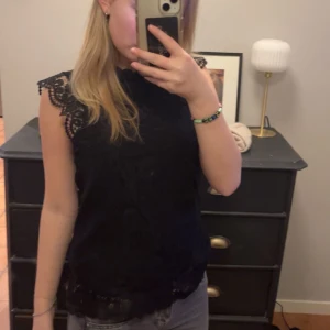 Svart topp med spets - Snygg svart topp med fina spetsdetaljer. Fina spets faller på armarna!! Skriv vid frågor🩷