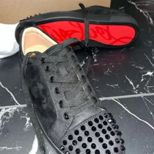 Svarta Louboutin - Snygga svarta sneakers med nitar på tån och ikonisk röd sula. Skorna har snörning och en stilren design som passar perfekt för en trendig look. Dom är välanvända och har inte kvar några äktahetsbevis därav priset. Lånade bilder. Dom kan rustas upp i betydligt finare skick med en tvätt men har inte orkat göra det. Kom privat för tydligare bilder!☺️💗