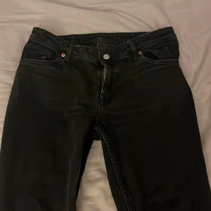 Svarta jeansbyxor - Snygga svarta lågmidjade jeansbyxor med dragkedja och knapp framtill. En stilren look. Perfekta för en avslappnad stil.