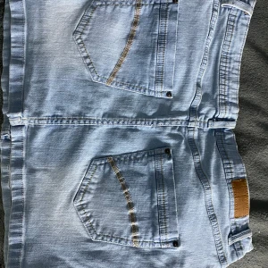 Ljusblå jeanskjol - Säljer denna jättesnygga jeanskjol som köptes förra sommaren. Den har en femfisckmodell och snygg design på fickorna där bak. Kjolen är lowwaist men den är lite längre