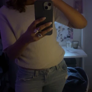 Beige kortärmad tröja - Säljer en stilren beige tröja med korta ärmar. Perfekt för en avslappnad look. Tröjan har en ribbad kant vid ärmslut och nederkant. Så snygg kortärmad stickat 