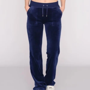 Mörkblå juicybyxor med snöre - Snygga mörkblå mjukisbyxor i sammet med snörning i midjan. Byxorna har en loose passform och praktiska fickor både fram och bak. Perfekta för en avslappnad stil.