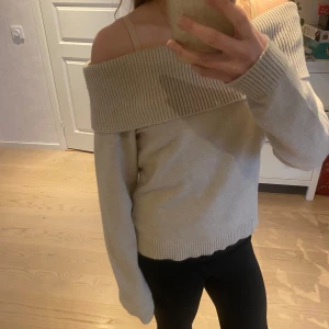 Beige offshoulder tröja - Säljer en beige offshoulder tröja med ribbade detaljer. Säljer efetrsom att den inte kommer till användning. Använd endast 1 gång. Köpte den från gina young i storlek 170