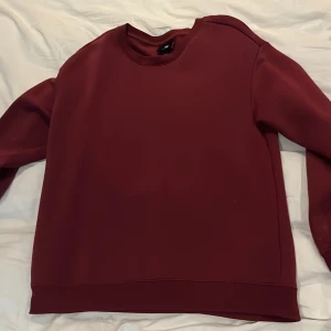 Vinröd tröja från H&M - Säljer en vinröd tröja från H&M i relaxed fit. Tröjan har långa ärmar och en enkel design, perfekt för en avslappnad stil. Nästan aldrig använd! 