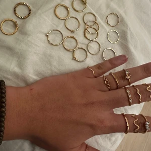 Set med guld-ringar - Ett stilrent set med flera tunna guld-ringar i olika designer. Perfekt för att mixa och matcha. Vissa ringar har små detaljer som stenar och mönster.